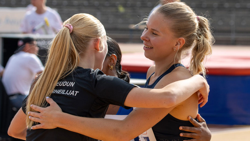 Naisurheilijat halaamassa iloisena toisiaan.